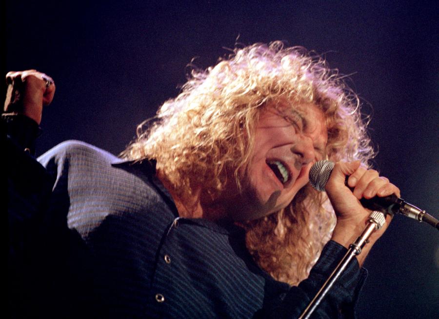 Close-up of Robert Plant singing into a microphone during a concert